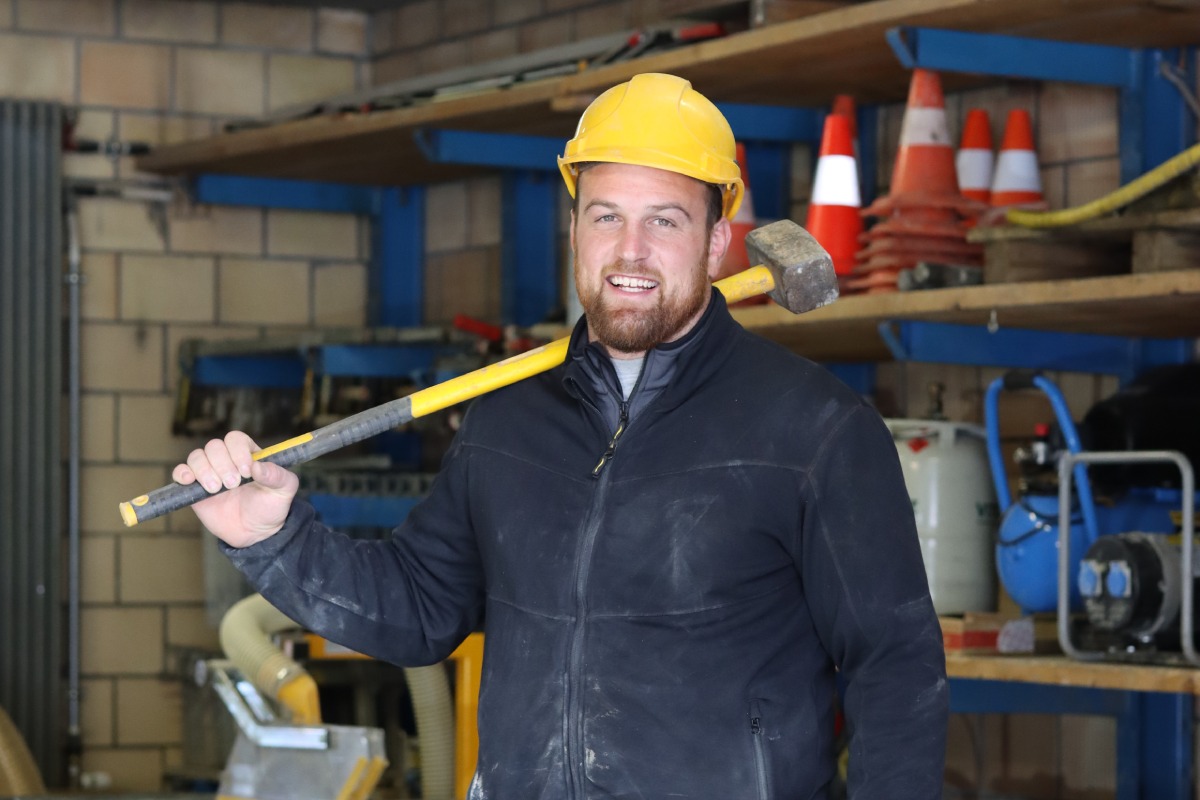 Matthias Aeschbacher mit Hammer und in Wikland Arbeitskleidern Matthias Aeschbacher trägt Wikland Arbeitskleider